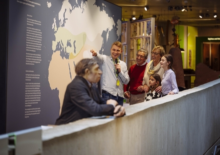 Bei Führung für Familien zeigt Museumsbegleiter auf Verbreitungskarte