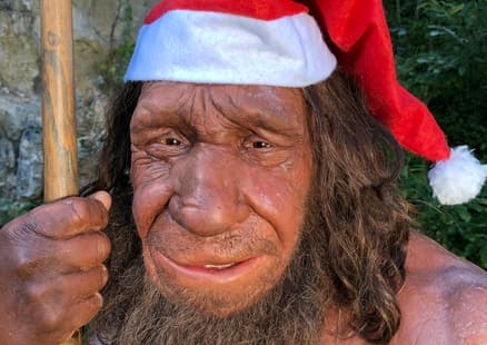 Neanderthaler Mr N trägt eine Nikolausmütze für Weihnachten