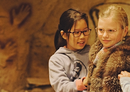 Kinder verkleidet als Steinzeitmenschen im Höhlenraum des Neanderthal Museum