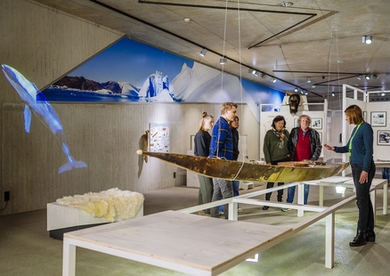 Besuchende bei Führung vor dem Kajak in der Sonderausstellung Eiszeitreise Grönland