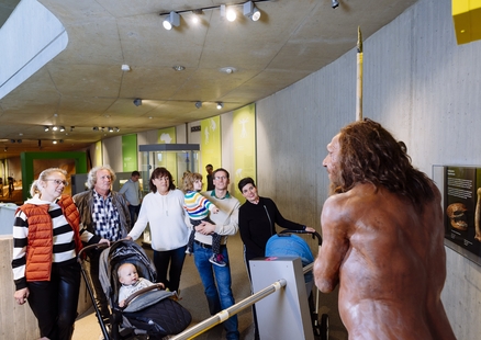 Familie schaut sich den Neanderthaler Mr N in der Dauerausstellung an