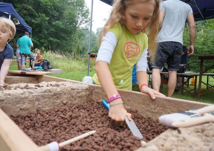 Kinder graben in Ausgrabungskisten beim Museumsfest