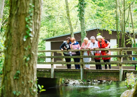 Erwachsene stehen auf Brücke beim Outdoor Kunstweg