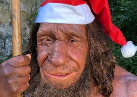 Neanderthaler Mr N trägt eine Nikolausmütze für Weihnachten