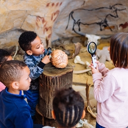 Kinder untersuchen Knochen im Höhlenraum