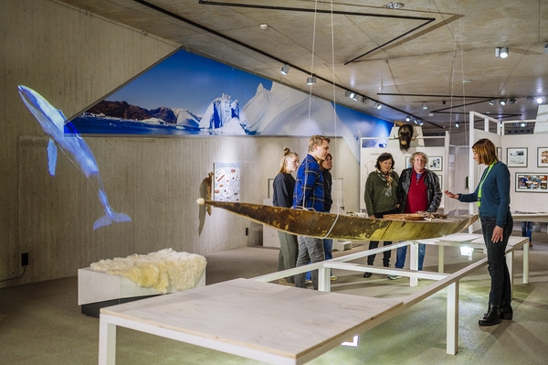 Besuchende bei Führung vor dem Kajak in der Sonderausstellung Eiszeitreise Grönland