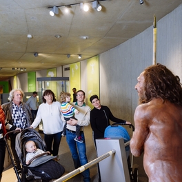 Familie schaut sich den Neanderthaler Mr N in der Dauerausstellung an