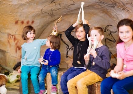 Kinder spielen mit Knochen im Höhlenraum