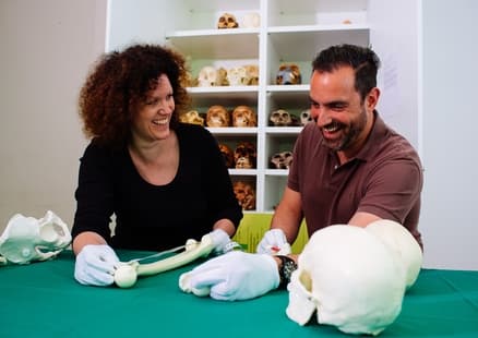 Erwachsene messen Humanfossilien bei Lehrerfortbildung in Steinzeitwerkstatt ab