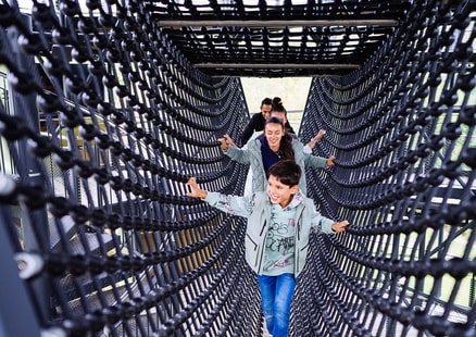 Familie in Klettertunnel im Erlebnisturm Höhlenblick bei der Fundstelle