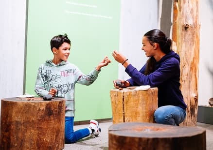 Kinder knacken Nüsse aus Steinzeit Action Pack in Ausstellung