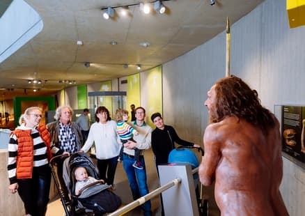 Familie schaut sich den Neanderthaler Mr N in der Dauerausstellung an