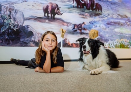 Kind und Hund liegen nebeneinander in Ausstellung beim DoggyDay