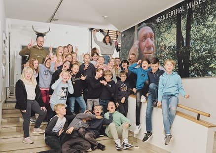 Gruppenfoto einer Schulklasse im Foyer der Steinzeitwerkstatt
