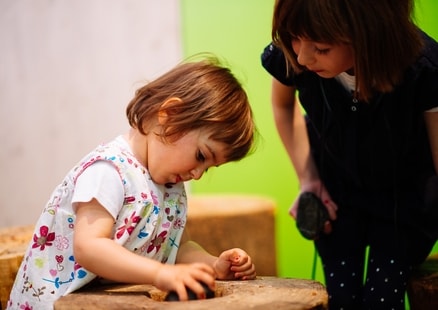 Kind knackt Nüsse aus Steinzeit Action Pack in Ausstellung