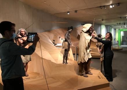 Frau steht in der Dauerausstellung und wird dabei gefilmt