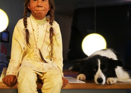Hund liegt neben Neanderthalerkind Kina in Ausstellung beim DoggyDay