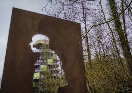 Blick auf Erlebnisturm Höhlenblick durch Silhouette von Neanderthaler bei Fundstelle